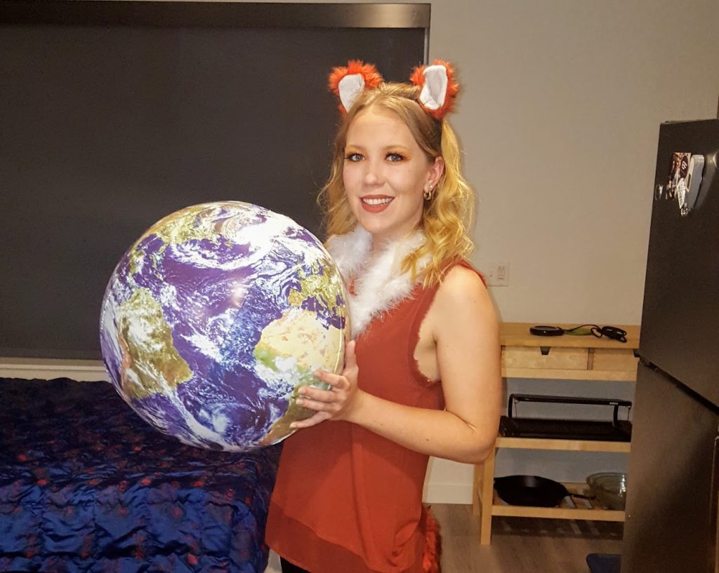 Liv is in a halloween costume dressed as the Firefox mascot - a red fox holding a globe